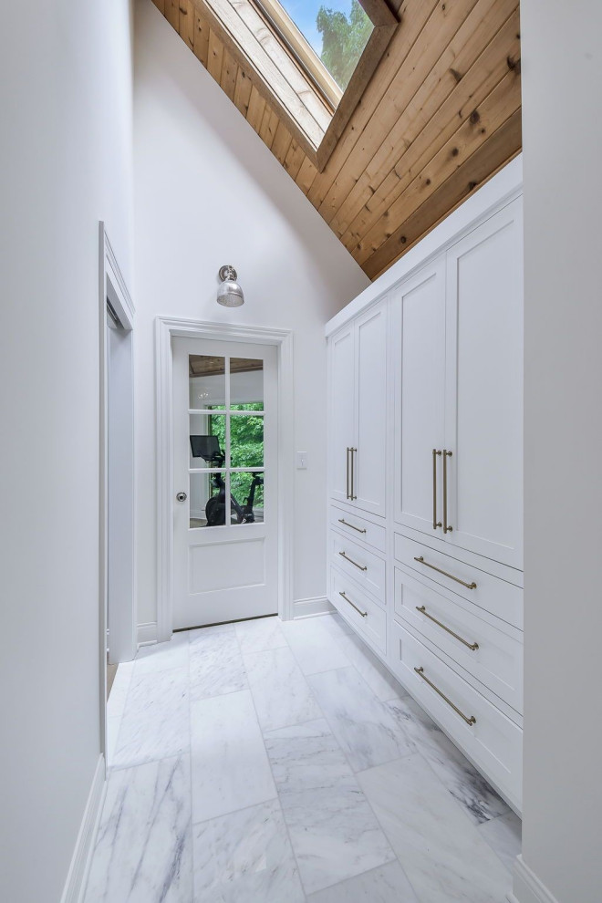Foto di un grande ingresso o corridoio con pareti bianche, pavimento in marmo e soffitto a volta