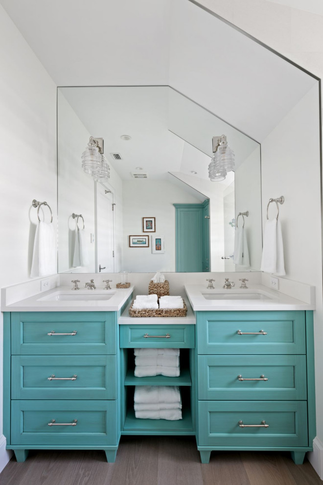 Inspiration for a small beach style kids bathroom in Tampa with furniture-like cabinets, turquoise cabinets, white walls, medium hardwood floors, an undermount sink, engineered quartz benchtops, grey floor and white benchtops.
