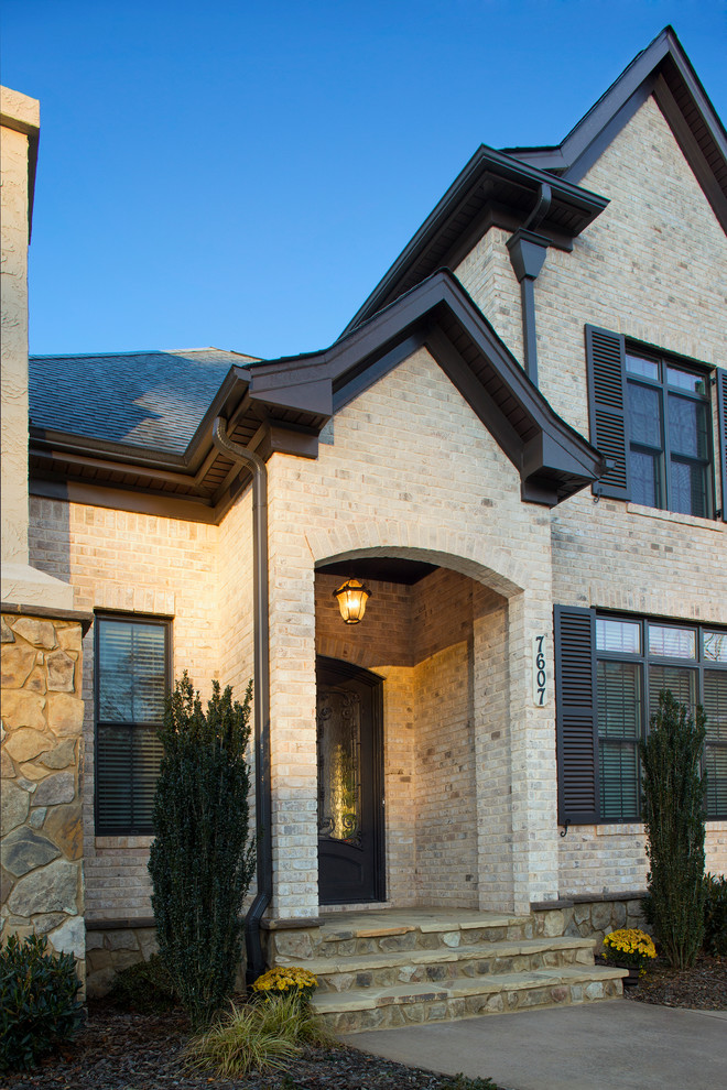 This is an example of a mid-sized traditional two-storey brick white exterior in Other.