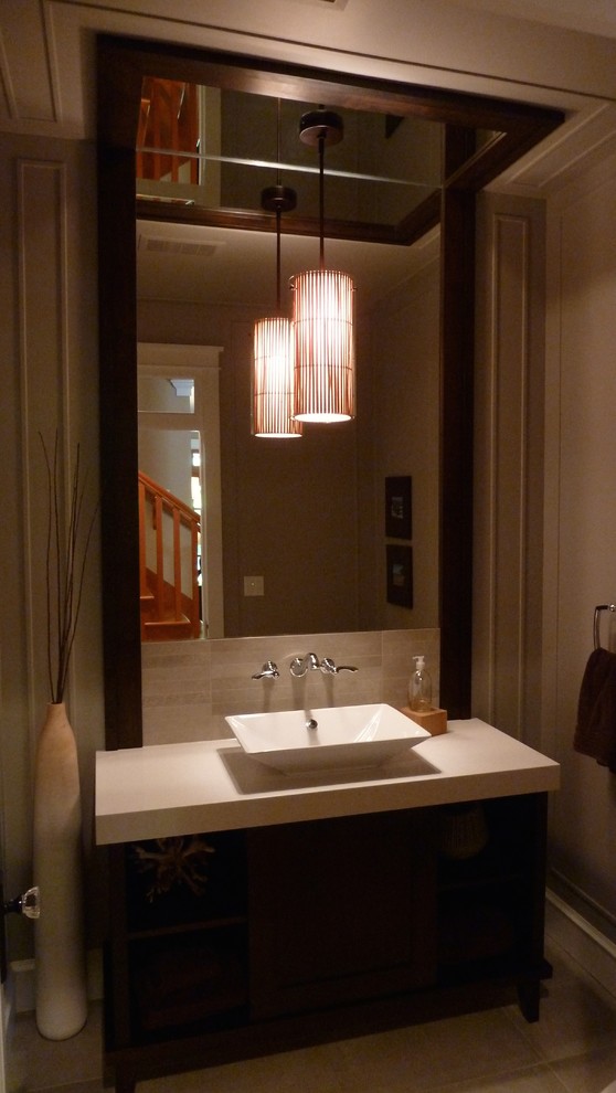 This is an example of a mid-sized arts and crafts powder room in Vancouver with flat-panel cabinets, black cabinets, beige walls and a vessel sink.