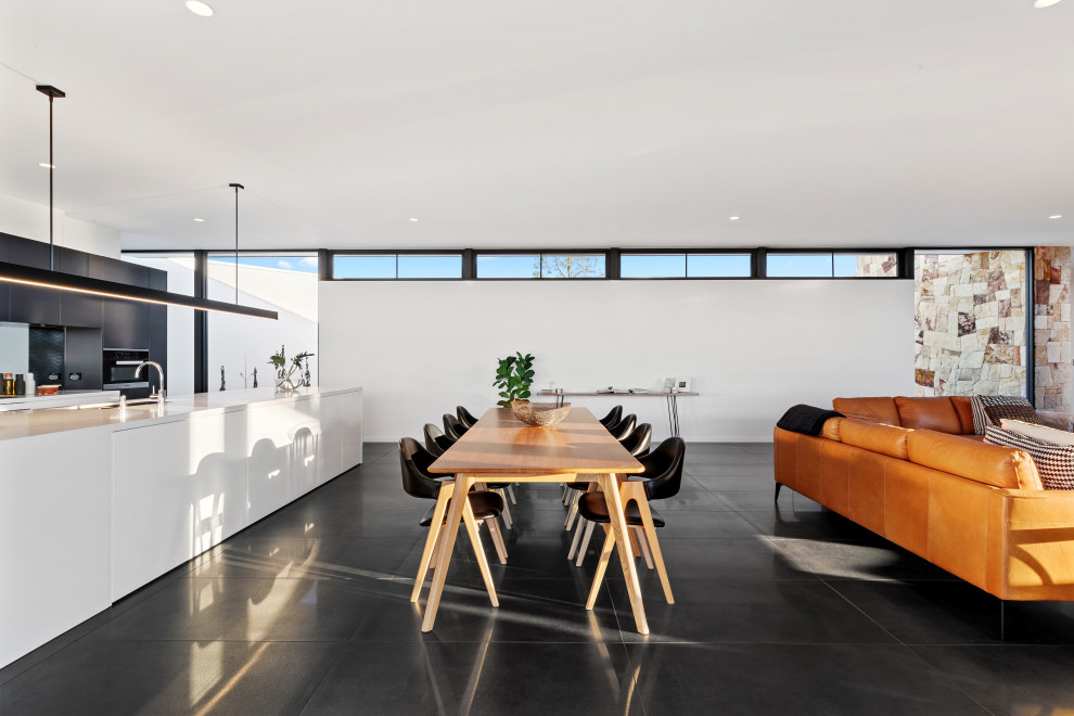 Inspiration for a contemporary dining room in Brisbane with white walls and black floor.
