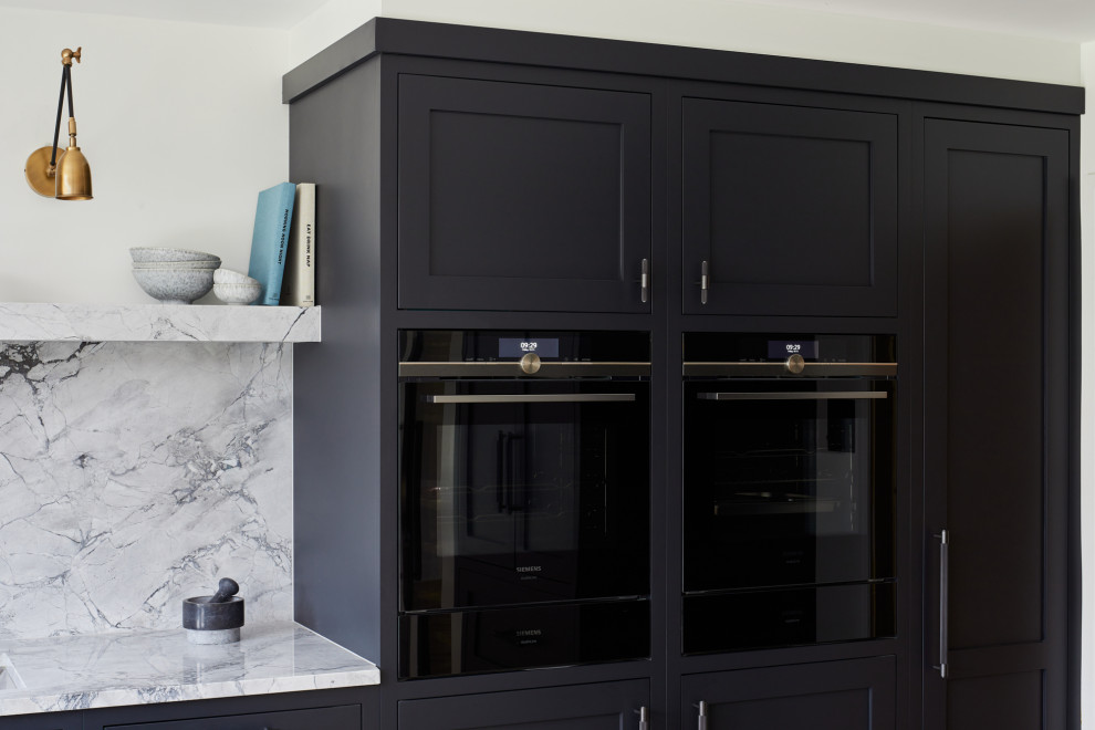 Large transitional l-shaped eat-in kitchen photo in London with recessed-panel cabinets, black cabinets and an island