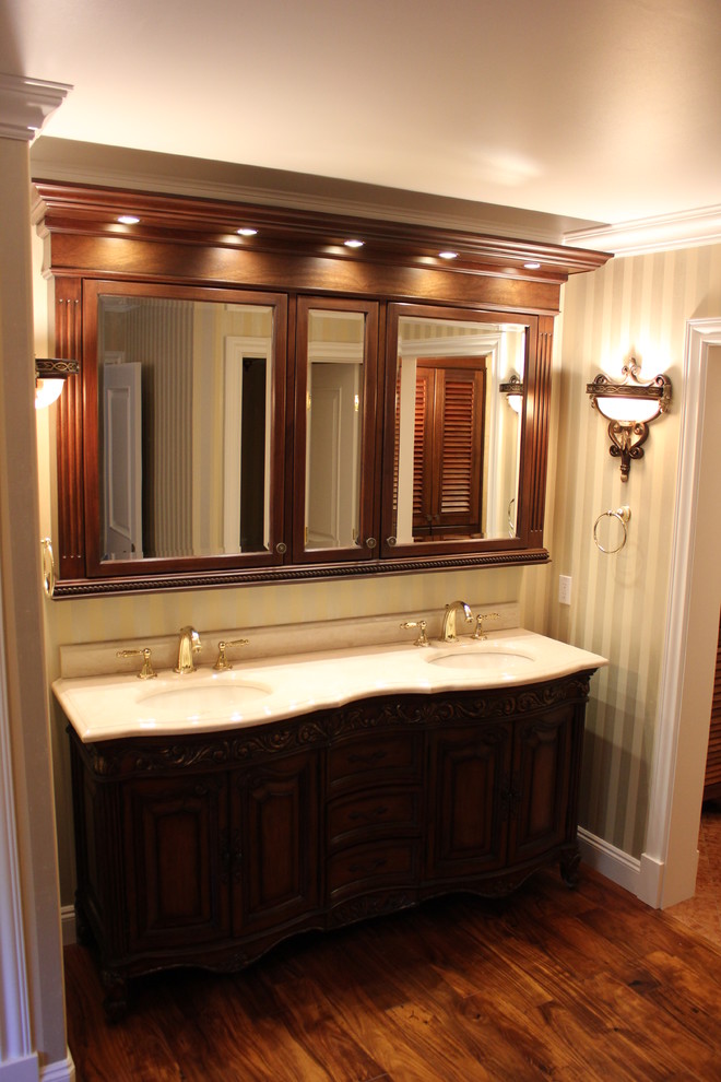 Design ideas for a mid-sized traditional master bathroom in Seattle with raised-panel cabinets, brown cabinets, an alcove shower, beige tile, marble, green walls, medium hardwood floors, an undermount sink, marble benchtops, brown floor and a hinged shower door.