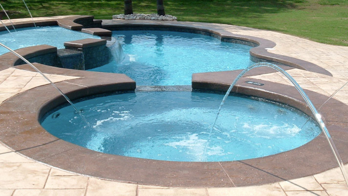 Large transitional backyard concrete paver and round hot tub photo in Chicago