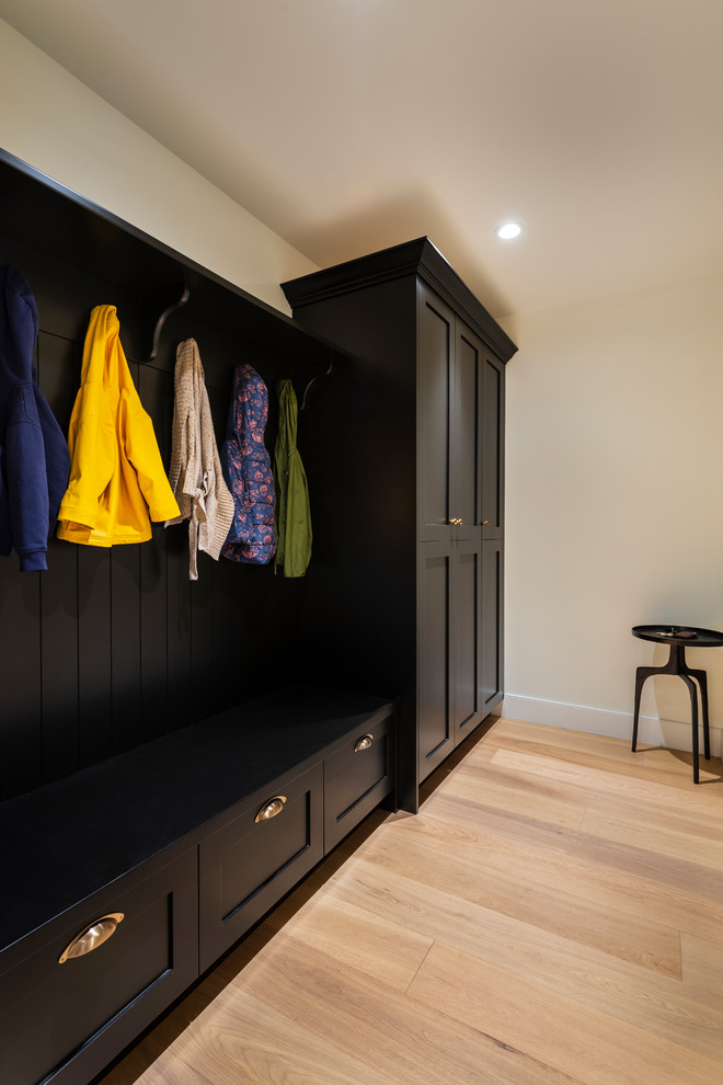Example of a mid-sized mountain style light wood floor and beige floor mudroom design in Vancouver with white walls