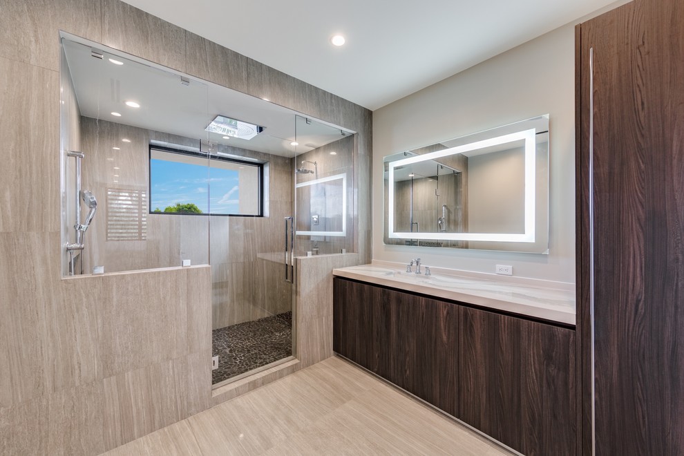 Large contemporary master bathroom in Miami with flat-panel cabinets, dark wood cabinets, an alcove shower, beige tile, a hinged shower door, a freestanding tub, porcelain tile, beige walls, light hardwood floors, an undermount sink, engineered quartz benchtops and beige floor.