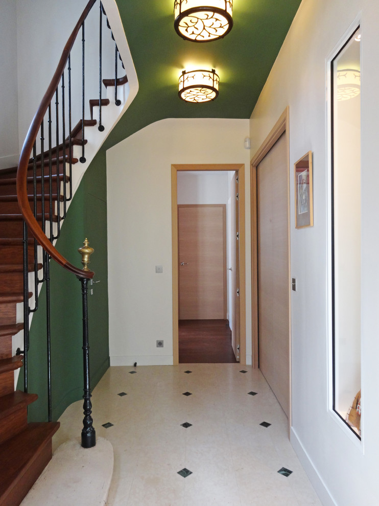 This is an example of a mid-sized transitional foyer in Paris with green walls.