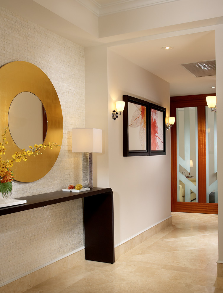 This is an example of a mid-sized contemporary hallway in Miami with beige walls, beige floor and marble floors.