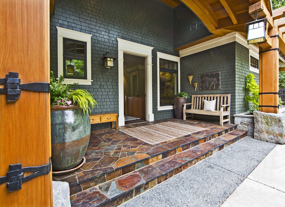Design ideas for a traditional verandah in Seattle with natural stone pavers and a roof extension.