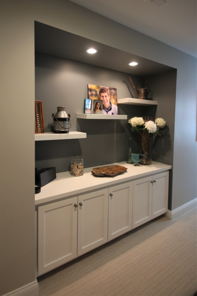 Inspiration for a mid-sized transitional look-out vinyl floor and beige floor basement remodel in Chicago with gray walls, a standard fireplace and a stone fireplace