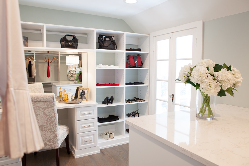 This is an example of a large country gender-neutral dressing room in Chicago with white cabinets, medium hardwood floors and raised-panel cabinets.