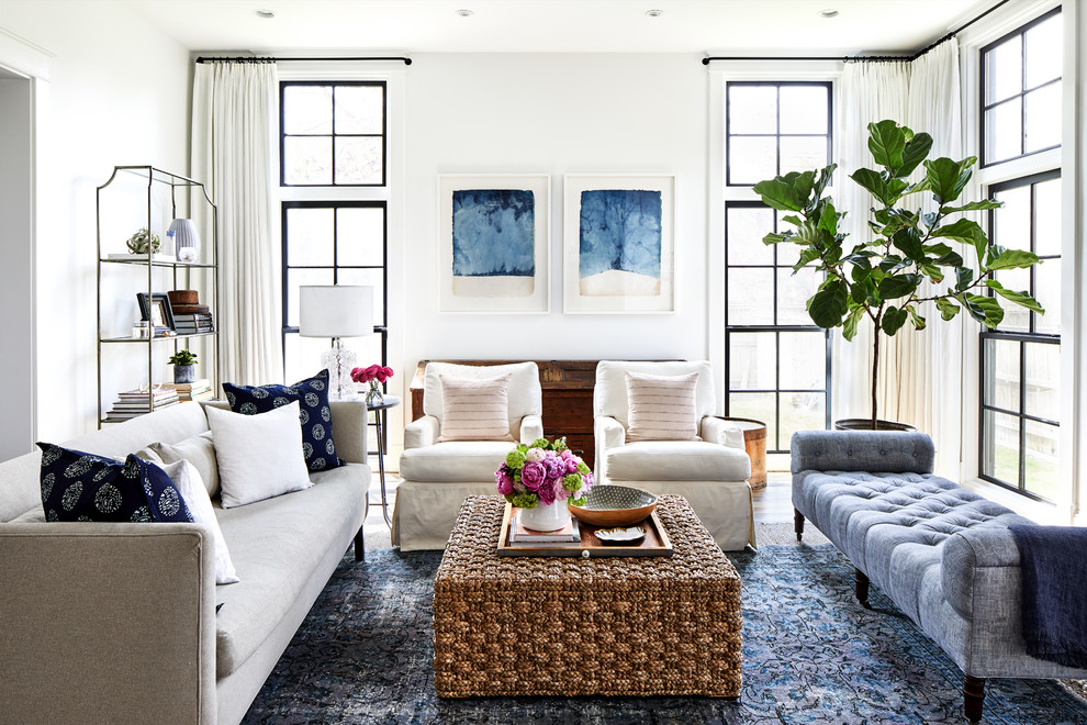 Inspiration for a beach style family room in DC Metro with white walls, medium hardwood floors and brown floor.