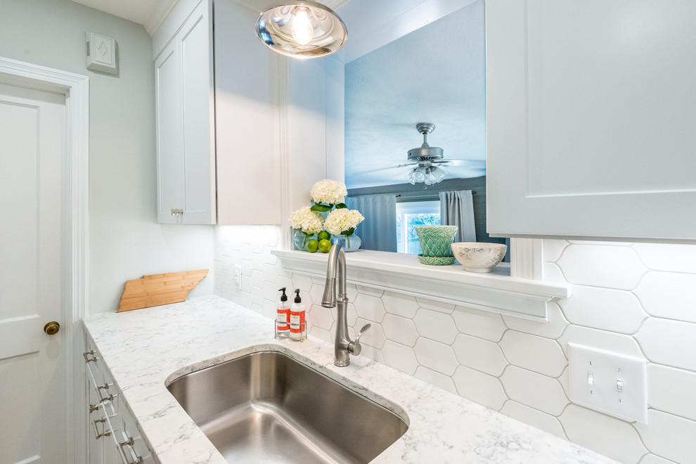 Transitional medium tone wood floor kitchen photo in Richmond with a single-bowl sink, shaker cabinets, white cabinets, quartzite countertops, white backsplash, mosaic tile backsplash, stainless steel appliances and a peninsula