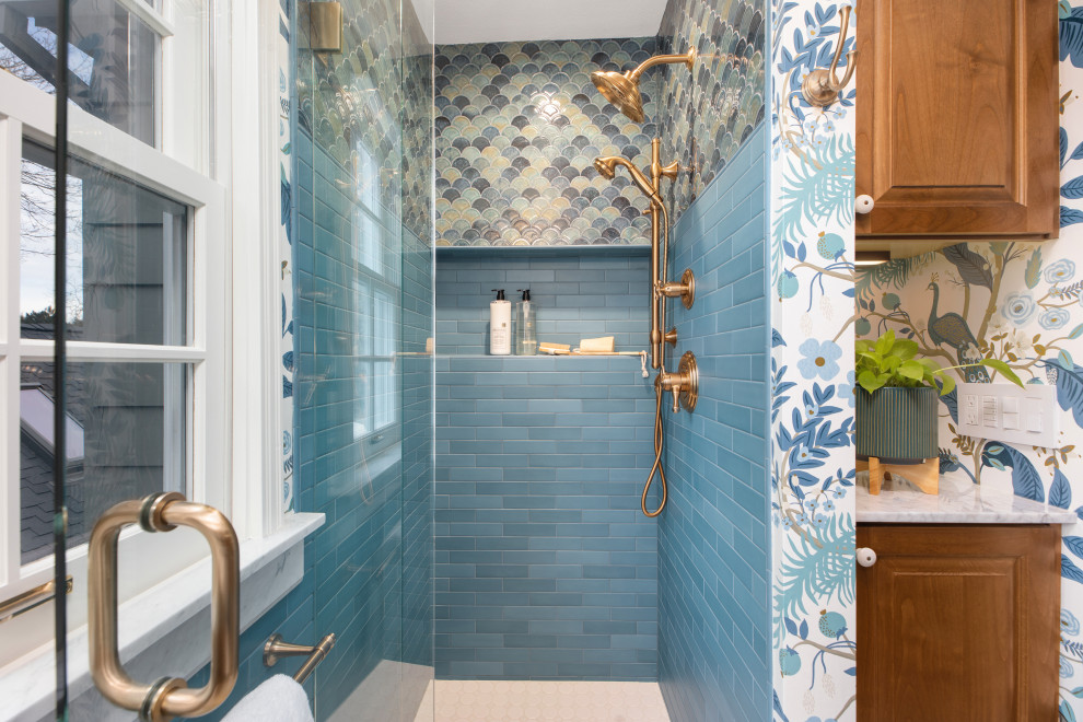 This is an example of a small traditional 3/4 bathroom in Portland with recessed-panel cabinets, dark wood cabinets, an alcove shower, a one-piece toilet, blue tile, ceramic tile, blue walls, ceramic floors, a drop-in sink, marble benchtops, white floor, a hinged shower door, white benchtops, a niche, a single vanity, a built-in vanity and wallpaper.