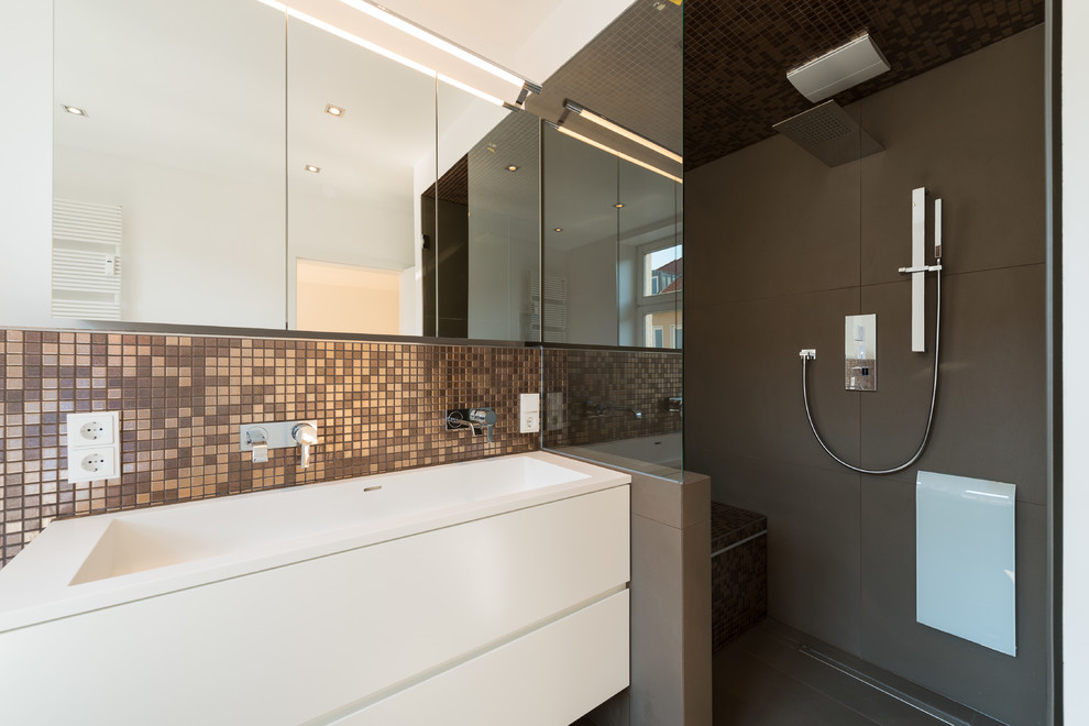 Mid-sized contemporary bathroom in Munich with an integrated sink, flat-panel cabinets, white cabinets, an alcove shower, brown tile, mosaic tile and white walls.