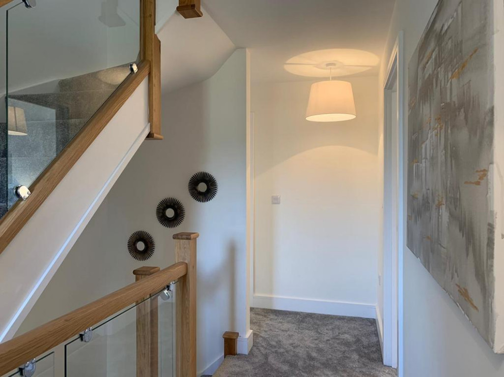 Design ideas for an expansive modern hallway in Essex with carpet.