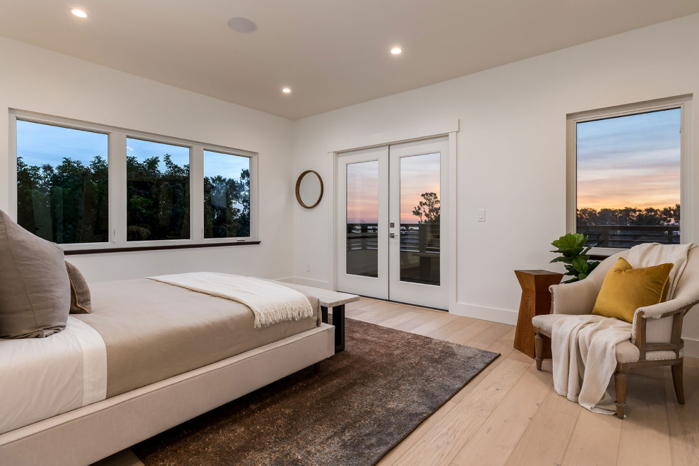 Design ideas for a large transitional master bedroom in San Diego with white walls, medium hardwood floors and beige floor.