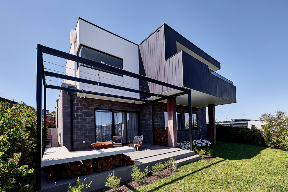 Стильный дизайн: большой, двухэтажный, черный частный загородный дом в современном стиле с облицовкой из металла, плоской крышей, металлической крышей и белой крышей - последний тренд