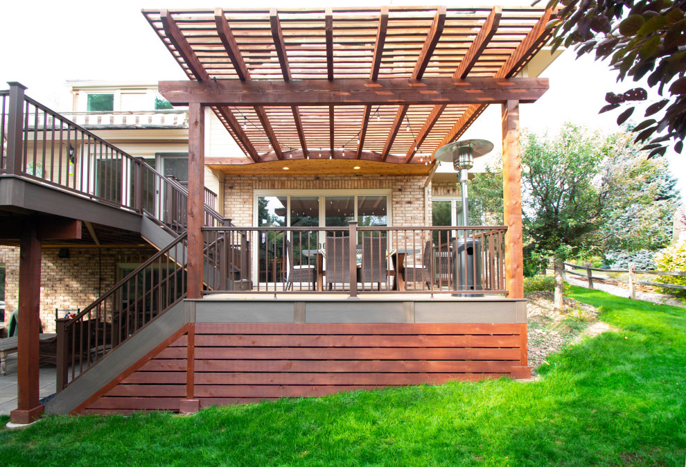 This is an example of a mid-sized transitional backyard and first floor deck in Denver with a pergola and metal railing.