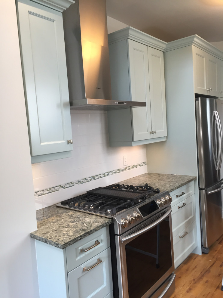 Enclosed kitchen - mid-sized transitional galley medium tone wood floor and brown floor enclosed kitchen idea in Ottawa with a double-bowl sink, recessed-panel cabinets, gray cabinets, granite countertops, porcelain backsplash, stainless steel appliances and gray countertops
