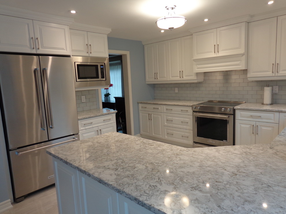 Example of a transitional porcelain tile kitchen design in Toronto with a double-bowl sink, raised-panel cabinets, white cabinets, quartz countertops, gray backsplash, glass tile backsplash and stainless steel appliances