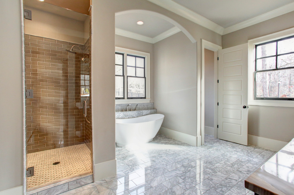 Ispirazione per una stanza da bagno eclettica con vasca freestanding, doccia alcova, piastrelle in pietra e lavabo sottopiano