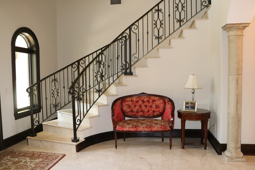 Photo of a mid-sized mediterranean foyer in Tampa with white walls, limestone floors and beige floor.