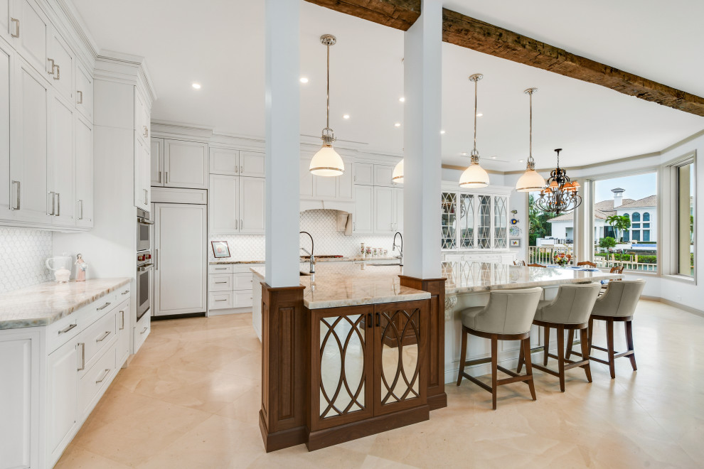 Expansive transitional l-shaped open plan kitchen in Other with raised-panel cabinets, white cabinets, quartzite benchtops, white splashback, porcelain splashback, panelled appliances, with island and white benchtop.