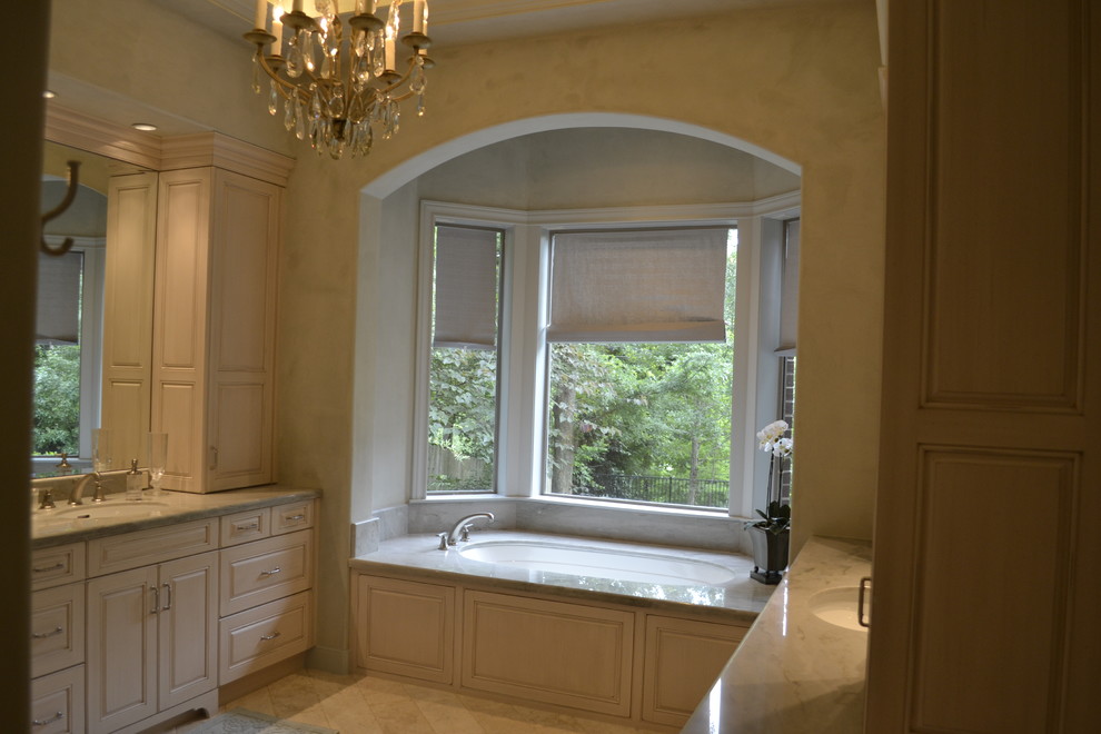Photo of a large traditional master bathroom in Houston with raised-panel cabinets, white cabinets, an undermount tub, beige tile, ceramic tile, beige walls, ceramic floors, an undermount sink and quartzite benchtops.