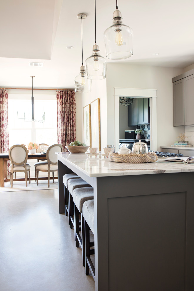 Large transitional concrete floor eat-in kitchen photo in Austin with shaker cabinets, gray cabinets, marble countertops, white backsplash, subway tile backsplash, stainless steel appliances, an island and a farmhouse sink