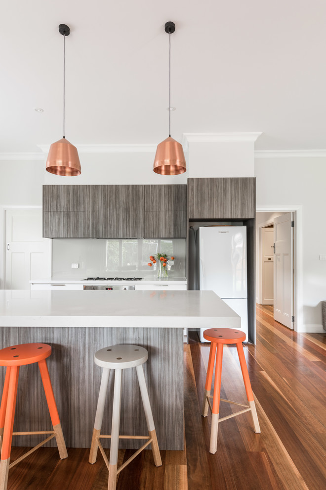 Design ideas for a mid-sized contemporary l-shaped eat-in kitchen in Melbourne with a drop-in sink, flat-panel cabinets, dark wood cabinets, quartz benchtops, grey splashback, glass sheet splashback, stainless steel appliances, medium hardwood floors and with island.