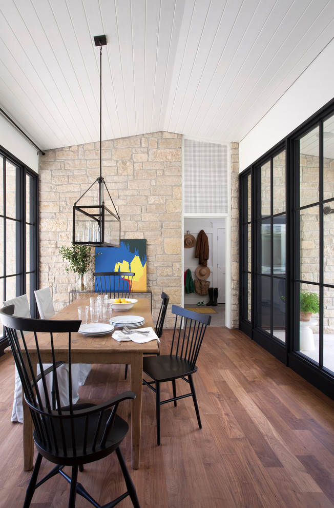 This is an example of a country dining room in Austin with dark hardwood floors.