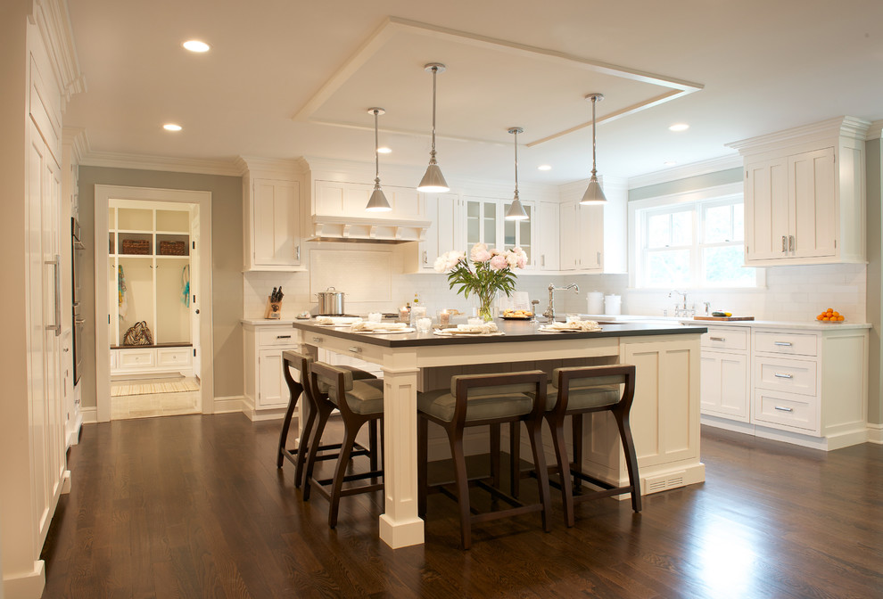 Example of a large transitional u-shaped dark wood floor open concept kitchen design in New York with a farmhouse sink, recessed-panel cabinets, white cabinets, quartzite countertops, white backsplash, stone tile backsplash, paneled appliances, gray walls and an island