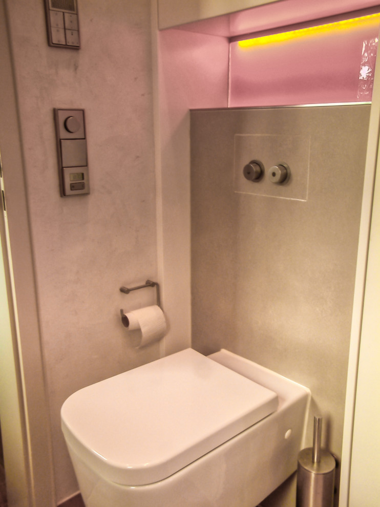 This is an example of a small contemporary 3/4 bathroom in Munich with flat-panel cabinets, white cabinets, a curbless shower, a two-piece toilet, beige tile, ceramic tile, beige walls, ceramic floors, an integrated sink, solid surface benchtops, beige floor, a hinged shower door, white benchtops, a single vanity, a floating vanity and recessed.