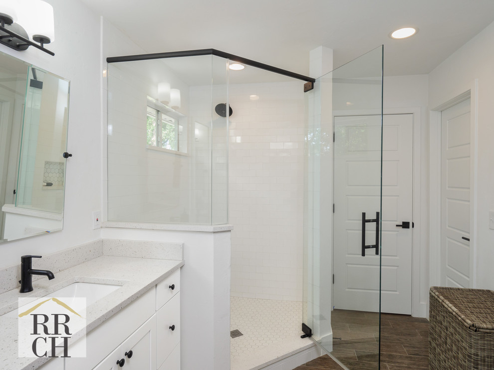 Design ideas for a country bathroom in Jacksonville with shaker cabinets, white cabinets, a two-piece toilet, medium hardwood floors, an undermount sink, engineered quartz benchtops, a hinged shower door and white benchtops.