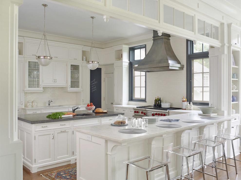 Inspiration for a traditional kitchen in New York with an undermount sink, glass-front cabinets, white cabinets, white splashback, subway tile splashback and stainless steel appliances.