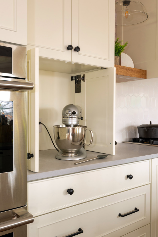Inspiration for a large medium tone wood floor and exposed beam eat-in kitchen remodel with white backsplash, stainless steel appliances and an island
