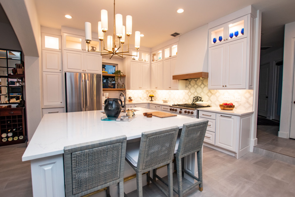 Transitional l-shaped porcelain tile and gray floor eat-in kitchen photo in Austin with an undermount sink, raised-panel cabinets, white cabinets, quartz countertops, white backsplash, marble backsplash, white appliances, an island and white countertops