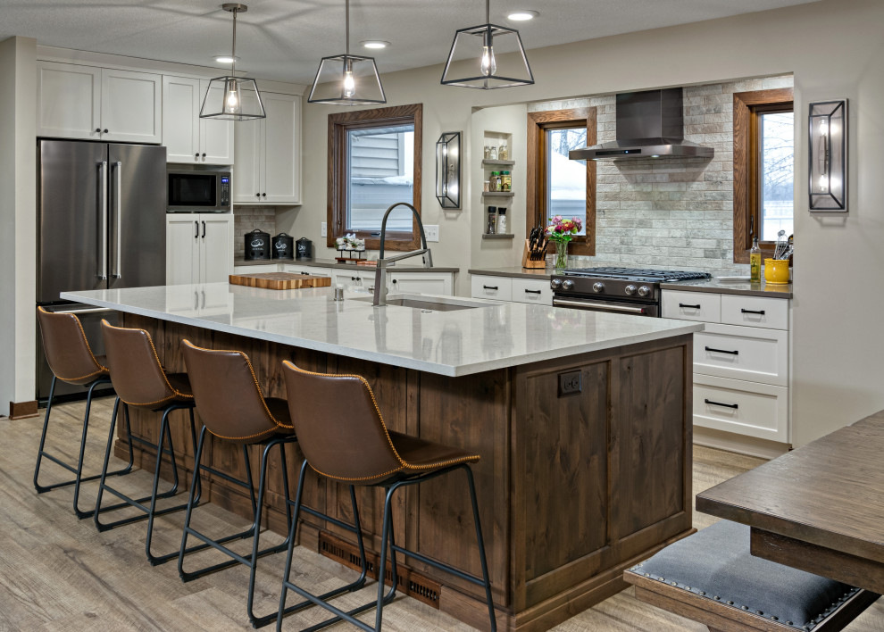 Large transitional l-shaped vinyl floor eat-in kitchen photo in Minneapolis with white cabinets, quartz countertops, gray backsplash, stone tile backsplash, stainless steel appliances, an island and white countertops