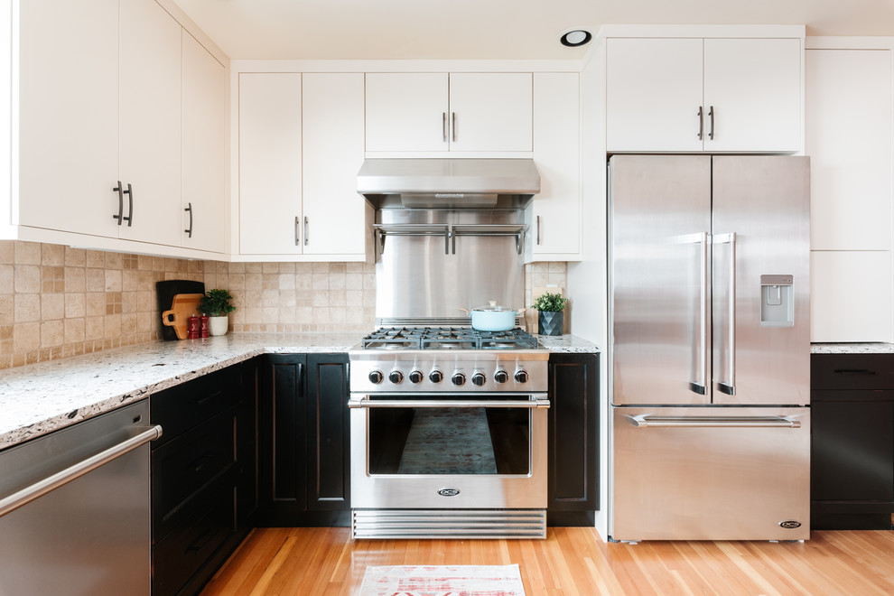 Mid-sized transitional u-shaped medium tone wood floor and brown floor eat-in kitchen photo with an undermount sink, shaker cabinets, distressed cabinets, quartz countertops, white backsplash, travertine backsplash, stainless steel appliances, a peninsula and multicolored countertops