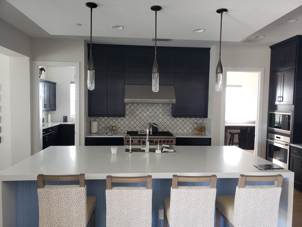 Inspiration for a huge transitional porcelain tile eat-in kitchen remodel in Phoenix with an undermount sink, shaker cabinets, dark wood cabinets, quartz countertops, multicolored backsplash, mosaic tile backsplash, stainless steel appliances, an island and white countertops