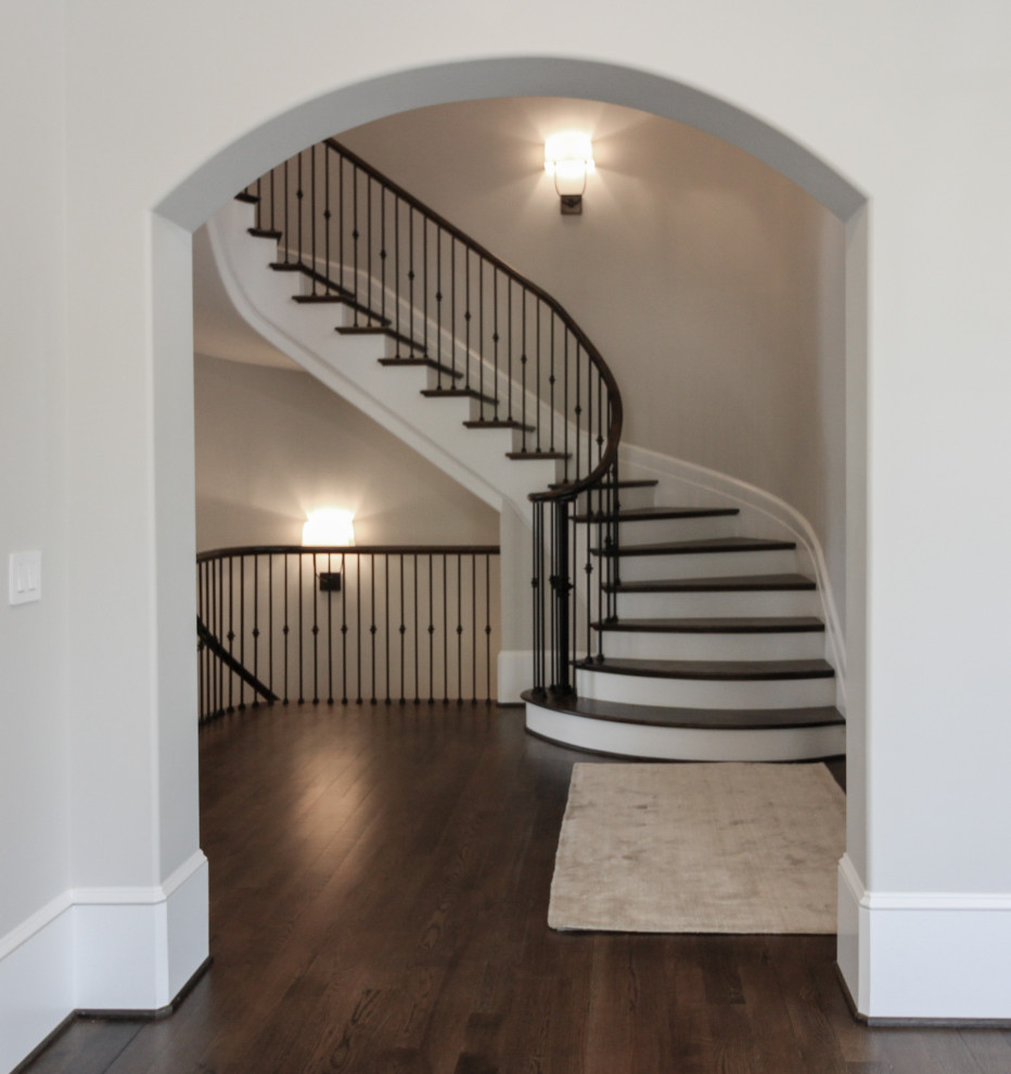 Inspiration for a large traditional wood floating staircase in DC Metro with painted wood risers and metal railing.