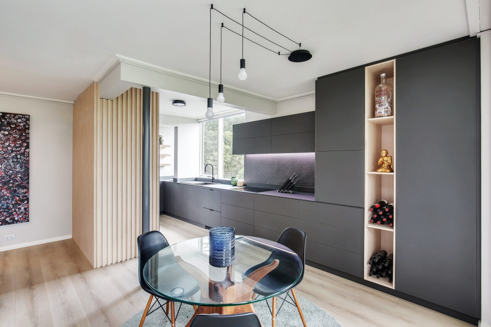Photo of a mid-sized contemporary u-shaped eat-in kitchen in Sydney with a single-bowl sink, flat-panel cabinets, brown cabinets, tile benchtops, brown splashback, ceramic splashback, stainless steel appliances, light hardwood floors, no island, brown floor, black benchtop and exposed beam.