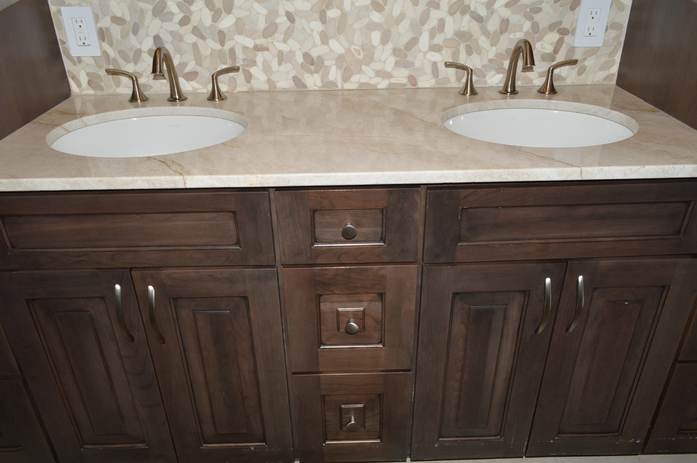 Mid-sized transitional master beige tile and cement tile bathroom photo in Boston with raised-panel cabinets, dark wood cabinets, a hot tub, an undermount sink, quartz countertops and beige countertops