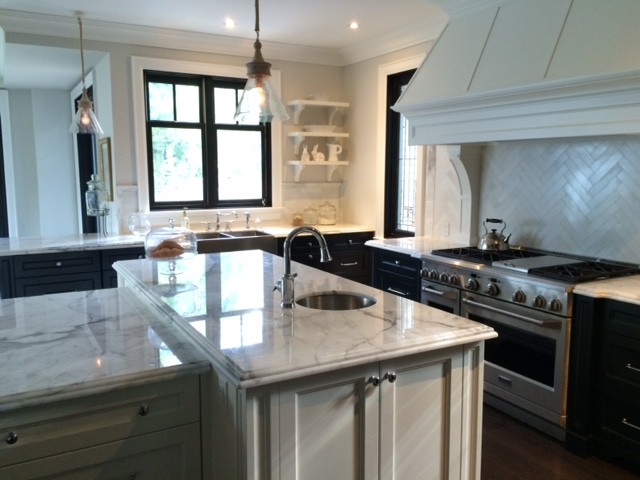 Example of a large transitional l-shaped dark wood floor eat-in kitchen design in Toronto with an undermount sink, raised-panel cabinets, dark wood cabinets, marble countertops, white backsplash, ceramic backsplash, stainless steel appliances and an island