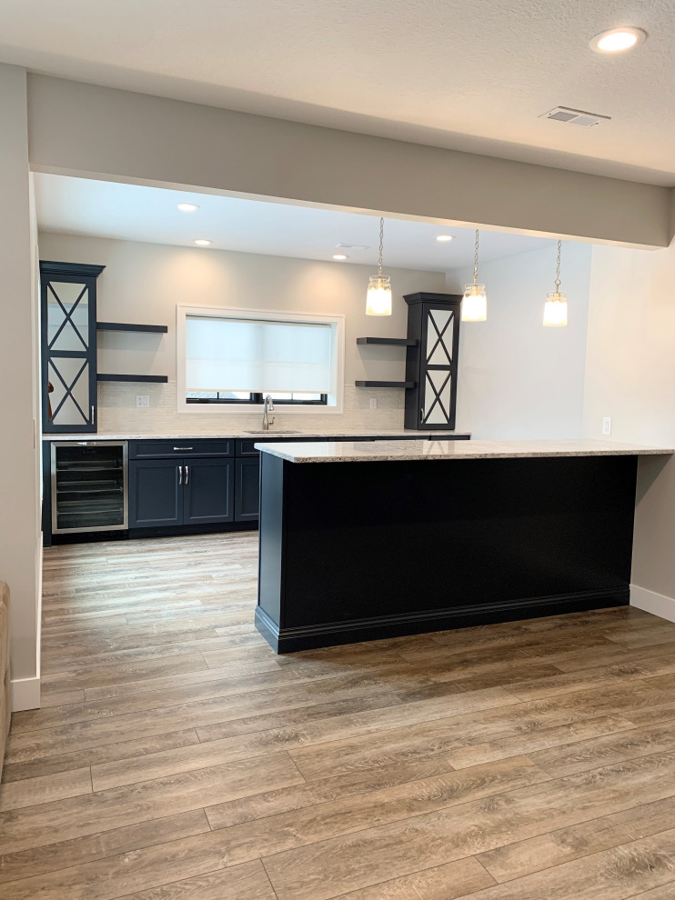 This is an example of a mid-sized single-wall wet bar in Other with an undermount sink, flat-panel cabinets, blue cabinets, quartz benchtops, beige splashback, grey floor and beige benchtop.
