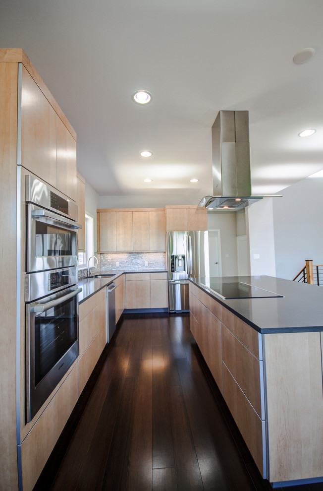 This is an example of a mid-sized contemporary l-shaped eat-in kitchen in Seattle with an undermount sink, flat-panel cabinets, wood benchtops, white splashback, glass tile splashback, stainless steel appliances, with island, light wood cabinets, dark hardwood floors and brown floor.