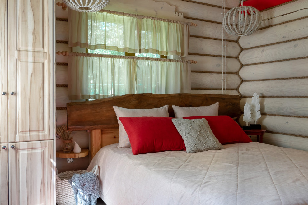 Kleines Rustikales Gästezimmer mit beiger Wandfarbe, Laminat, beigem Boden, freigelegten Dachbalken und Holzwänden in Sonstige