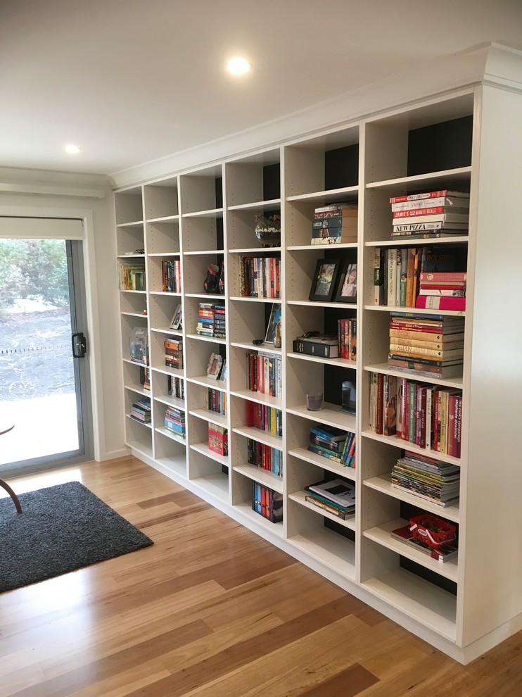 Large contemporary open concept family room in Canberra - Queanbeyan with a library, white walls, medium hardwood floors, no fireplace, no tv and multi-coloured floor.