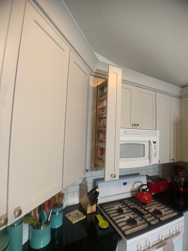 Inspiration for a small transitional u-shaped ceramic tile eat-in kitchen remodel in Orlando with an undermount sink, shaker cabinets, gray cabinets, granite countertops, subway tile backsplash and no island